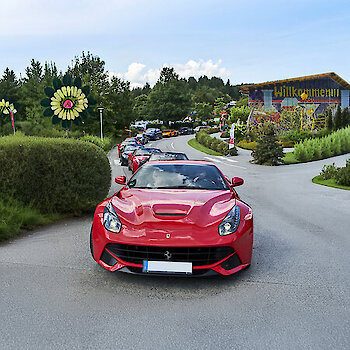 Roter Ferrari vor dem JOSKA Eingangsbereich – Highlight des Treffens zieht zahlreiche Besucher an.